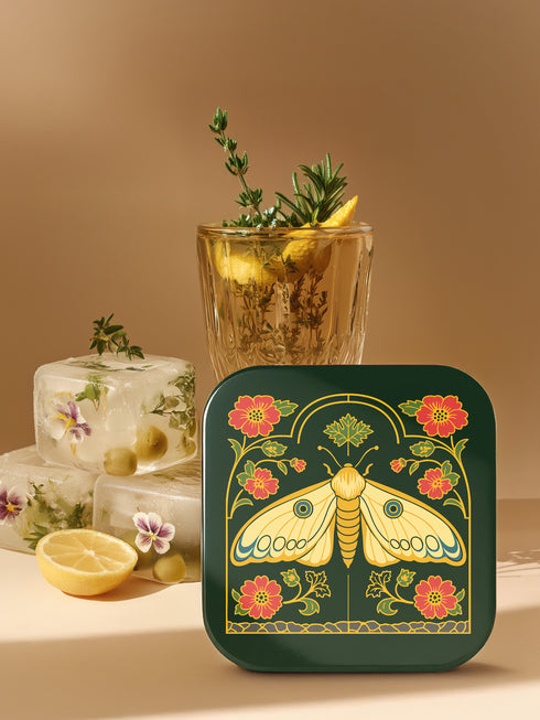 A set of four square hardboard coasters with smoothly rounded corners and a protective high-gloss finish. Each coaster features a unique, highly detailed Art Nouveau style illustration of a moth centered against a dark, botanical background. The intricate artwork uses a rich, moody color palette of deep forest greens, ochre, muted olive, crimson, and black, evoking a vintage, scholarly feel. These decorative drinkware accessories are designed for coffee table and bar cart use.